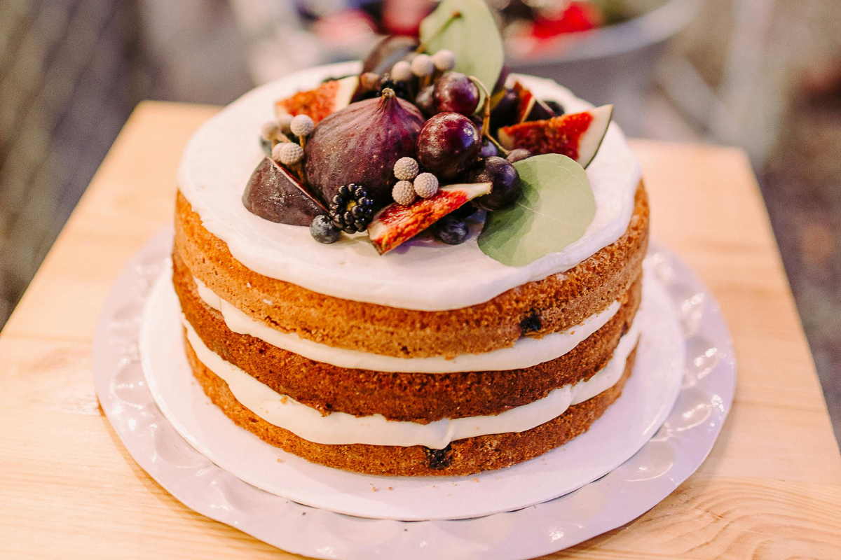 Baking with cream cheese can yield stunning results like this three-tier cake adorned with cream cheese frosting and topped with fresh figs, grapes, and berries.